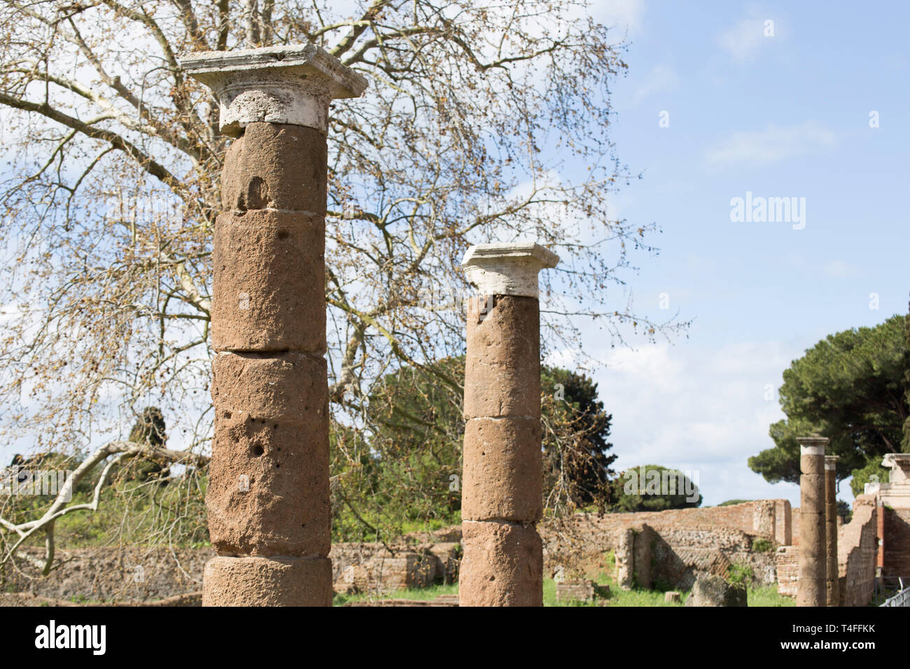 Paesaggio di scavi archeologici di Ostia Antica : la vista prospettica delle colonne romane - selezionato focus sulla prima colonna Foto Stock