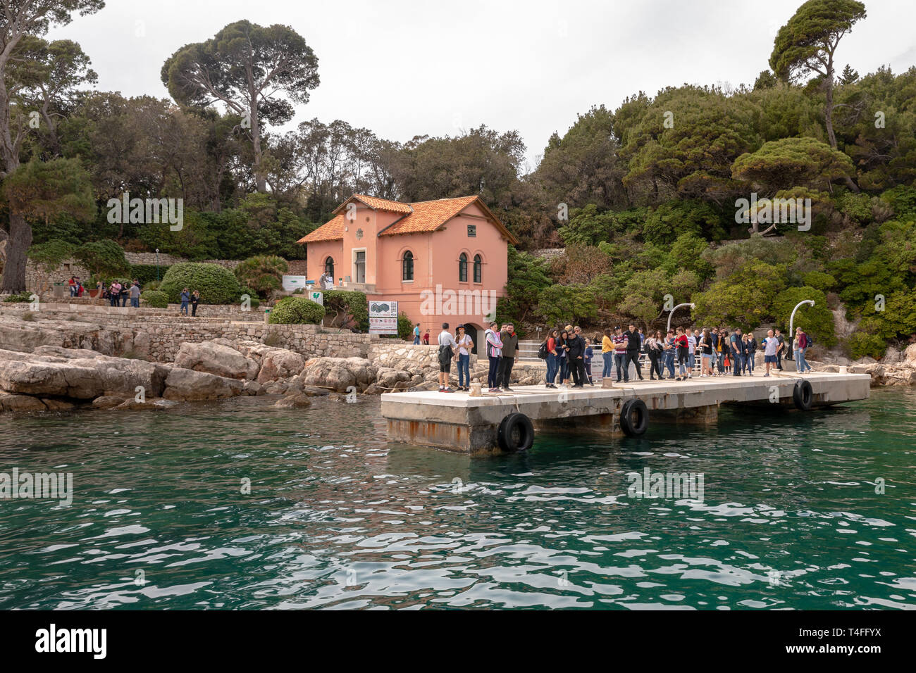 Isola di LOKRUM, Dubrovnik in Croazia - Aprile 2019: Turisti in attesa per il traghetto, guardaboschi casa sullo sfondo. Foto Stock