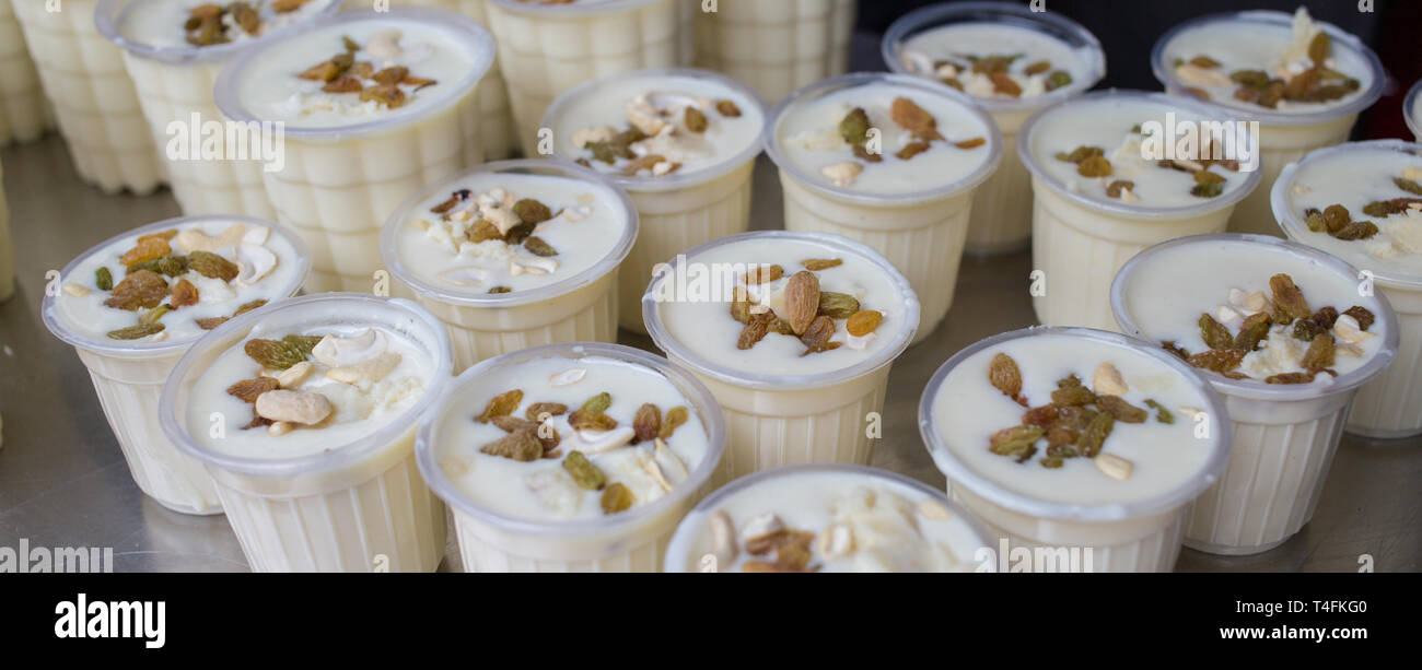 Il Lassi fresco, un tradizionale indiana yogurt drink, in tazze presso un fornitore del mercato. Foto Stock