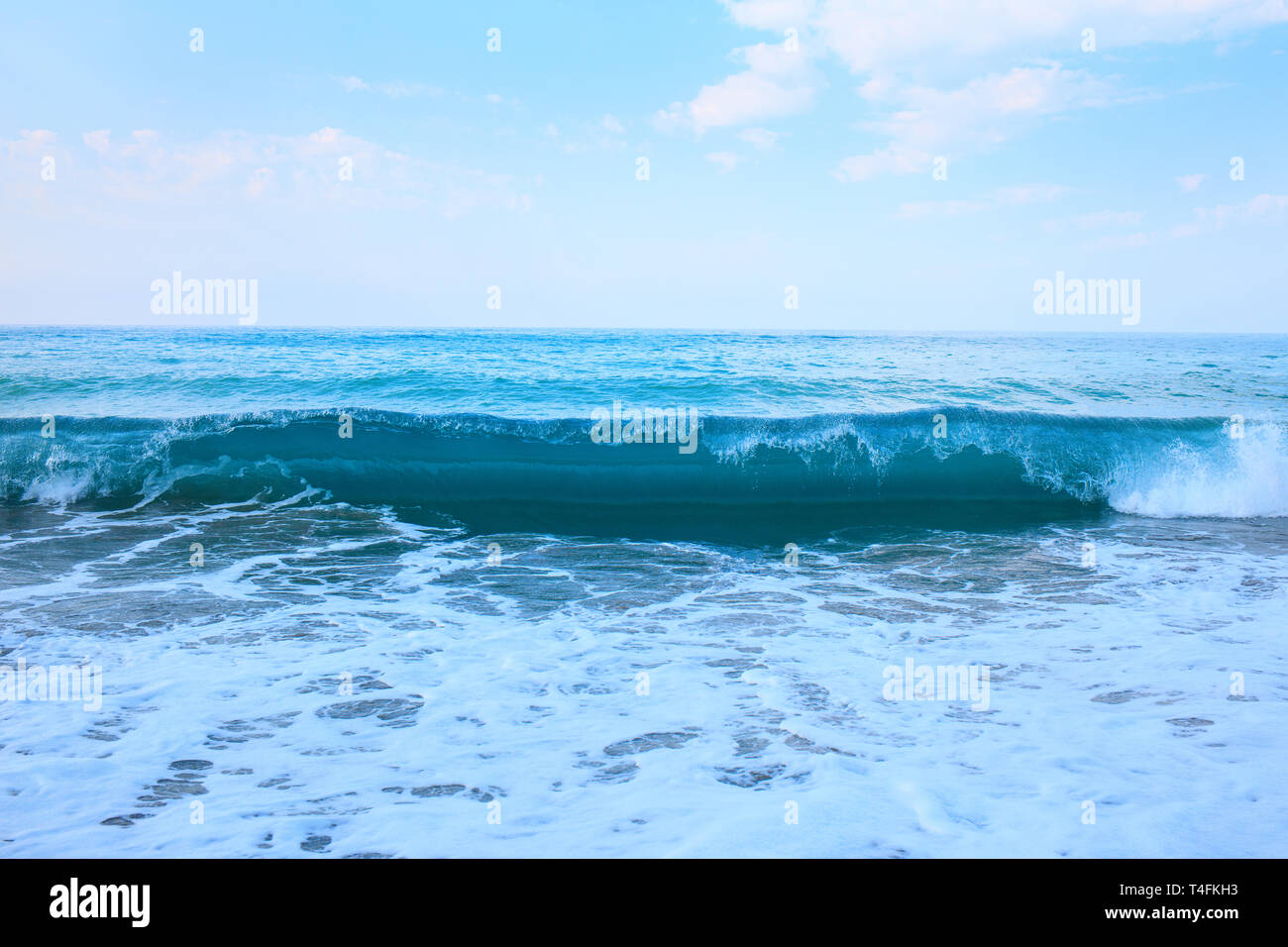 Bellissima vista di schizzi onde blu vicino alla spiaggia. Foto Stock