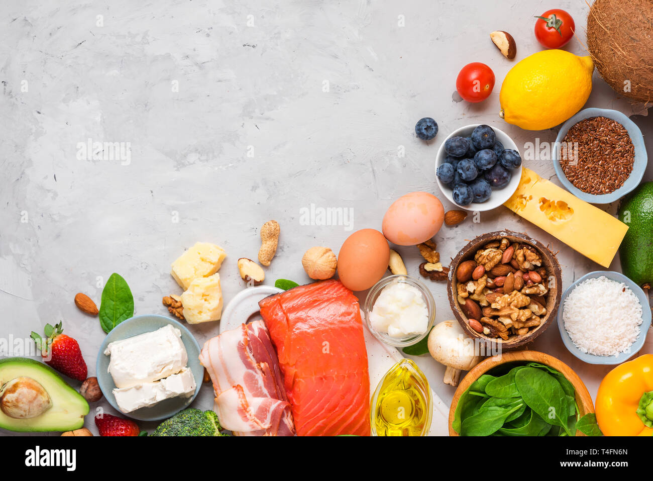 Dieta cheto concetto. Ketogenic la dieta alimentare. Equilibrato low-carb sfondo alimentare. Verdure, pesce, carne, formaggio, i dadi su calcestruzzo sfondo. vista superiore Foto Stock