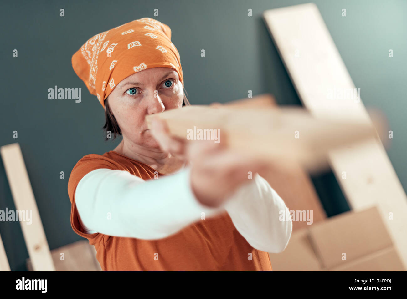 Falegname femmina esaminando plank per diy in legno Progetto nel laboratorio di falegnameria, il fuoco selettivo Foto Stock