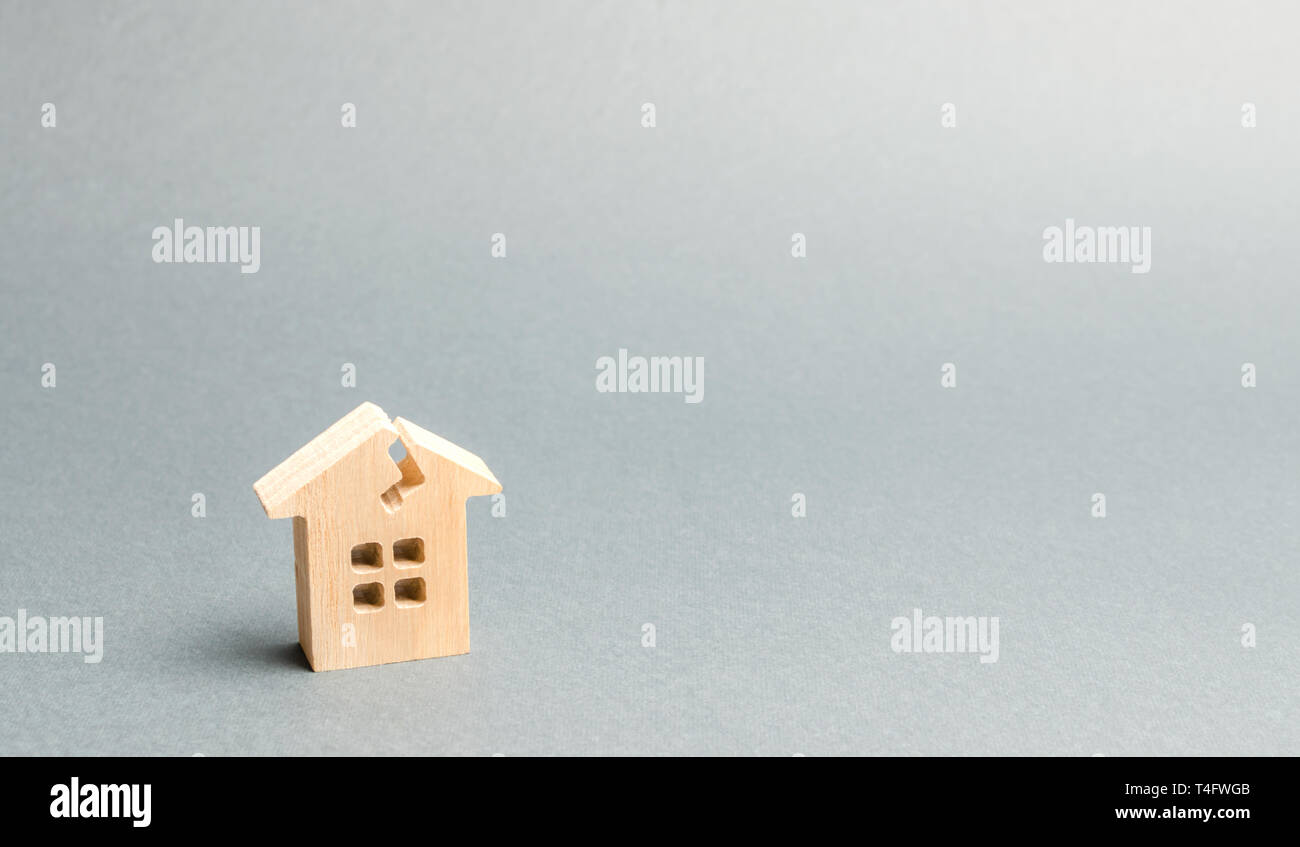 Una casa in legno con una crepa. Il concetto di una casa danneggiata, fatiscente alloggiamento. Home riparazione dopo la catastrofe. Lavori di ristrutturazione e restauro della vecchia build Foto Stock