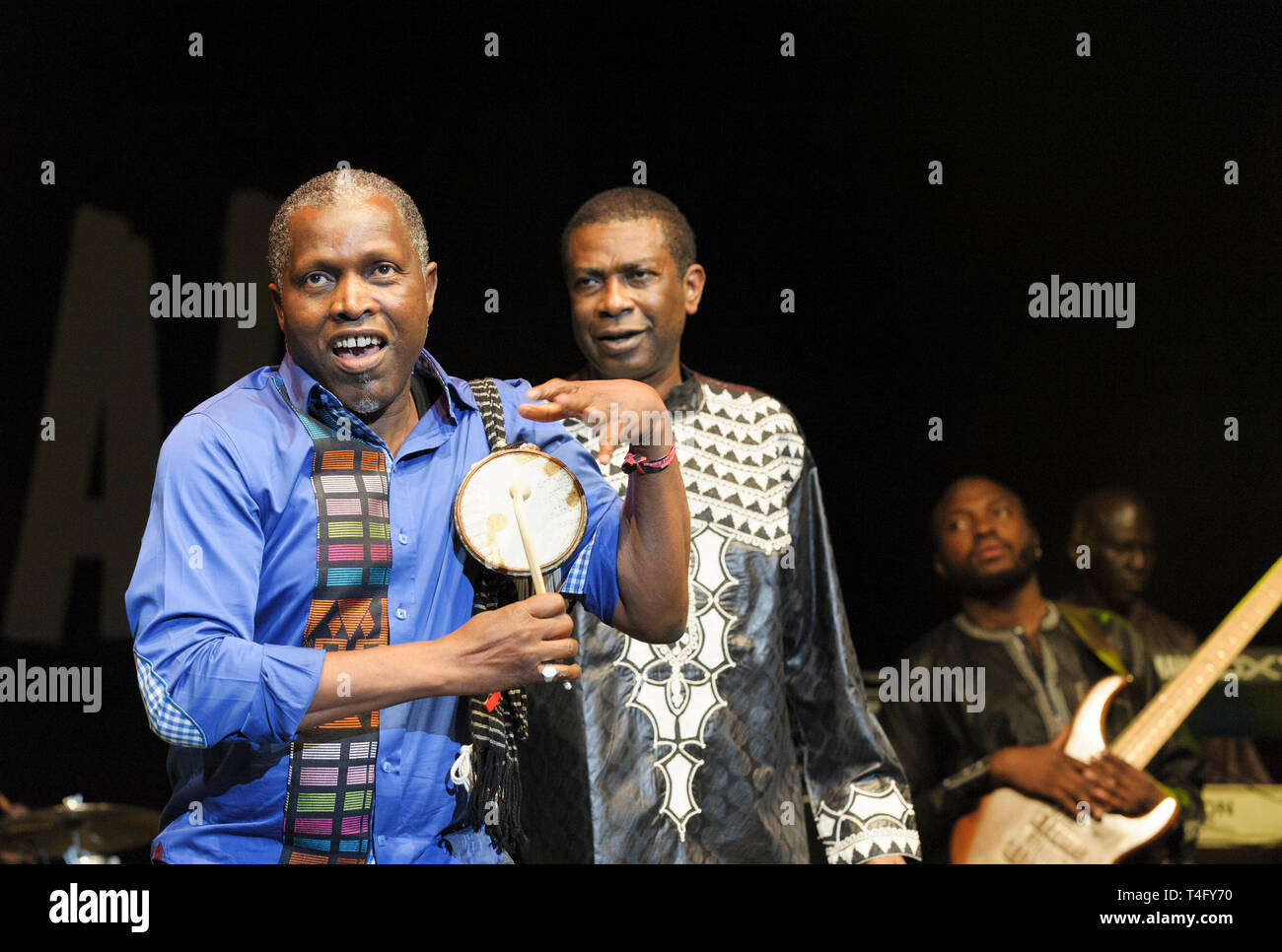 Tama (Tamburo Parlante) player Assane Thiam eseguendo con Youssou N'Dour al Womad Festival, Malmesbury, Regno Unito. Luglio 26, 2014 Foto Stock
