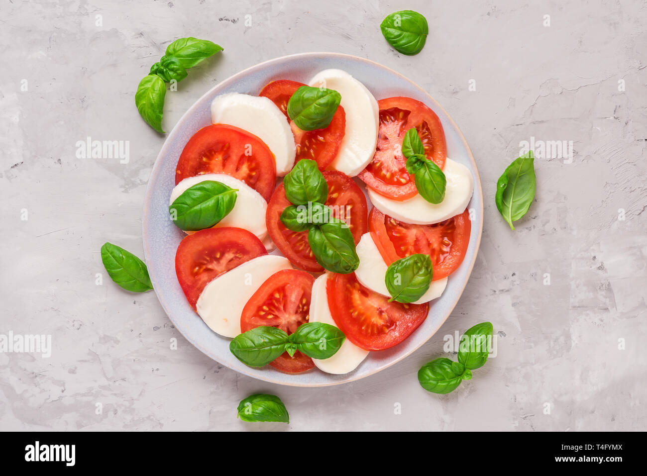 Piastra di italiano insalata caprese in una lastra di cemento grigio Sfondo. cibo sano. vista superiore. laici piatta Foto Stock