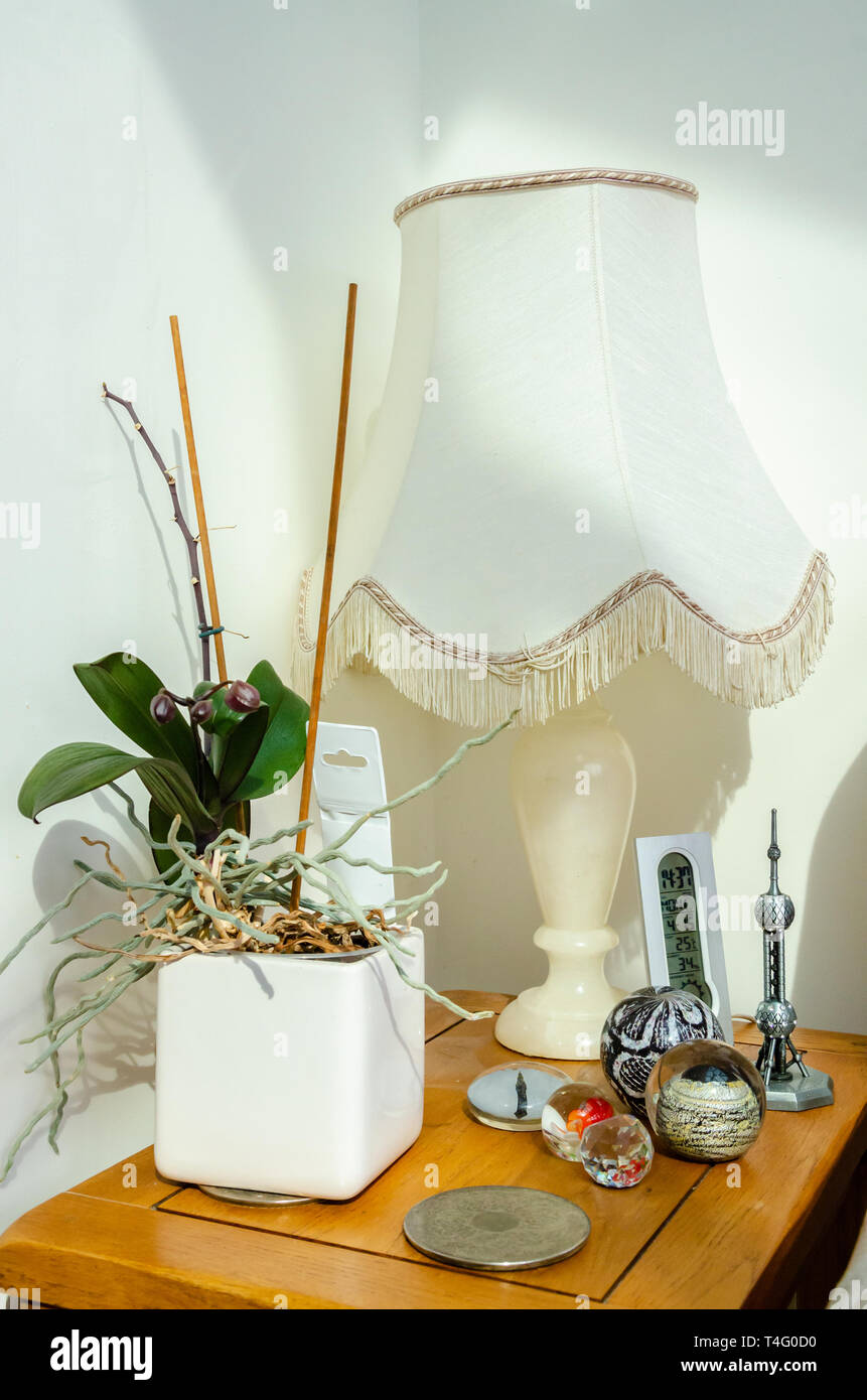 Ornamenti su un tavolo in un angolo della camera rendono l'interno dell'atmosfera di casa familiare. Foto Stock