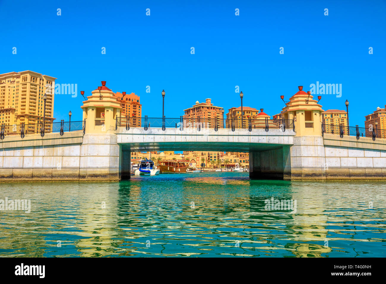 Ingresso e ponte di Porto saudita Marina all'Pearl-Qatar, Doha nel Golfo Persico, Medio Oriente dal taxi d'acqua. Giornata di sole e cielo blu. Copia dello spazio. Foto Stock