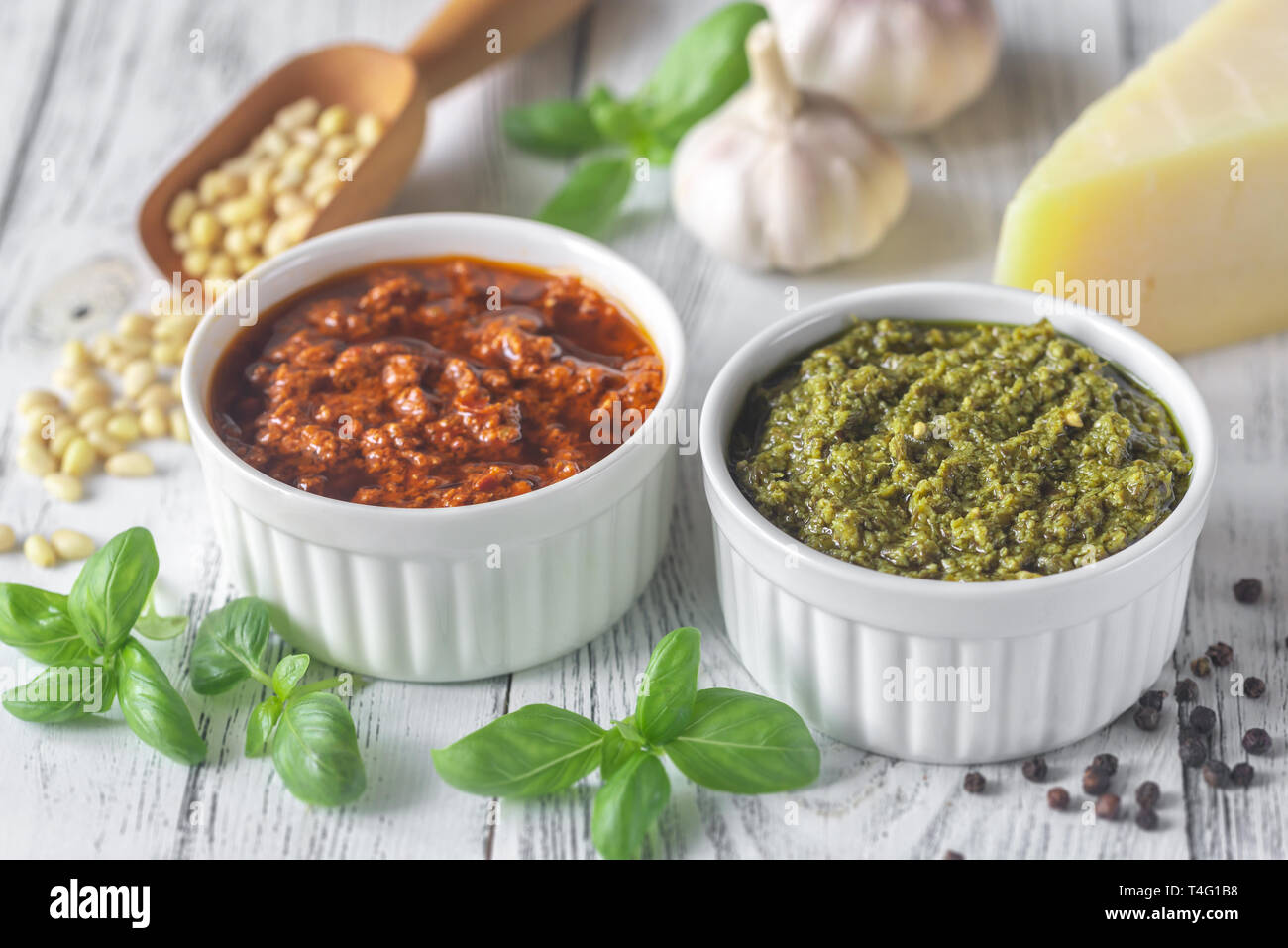 Bocce di classico e pomodori secchi pesto con ingredienti in bianco sullo sfondo di legno Foto Stock