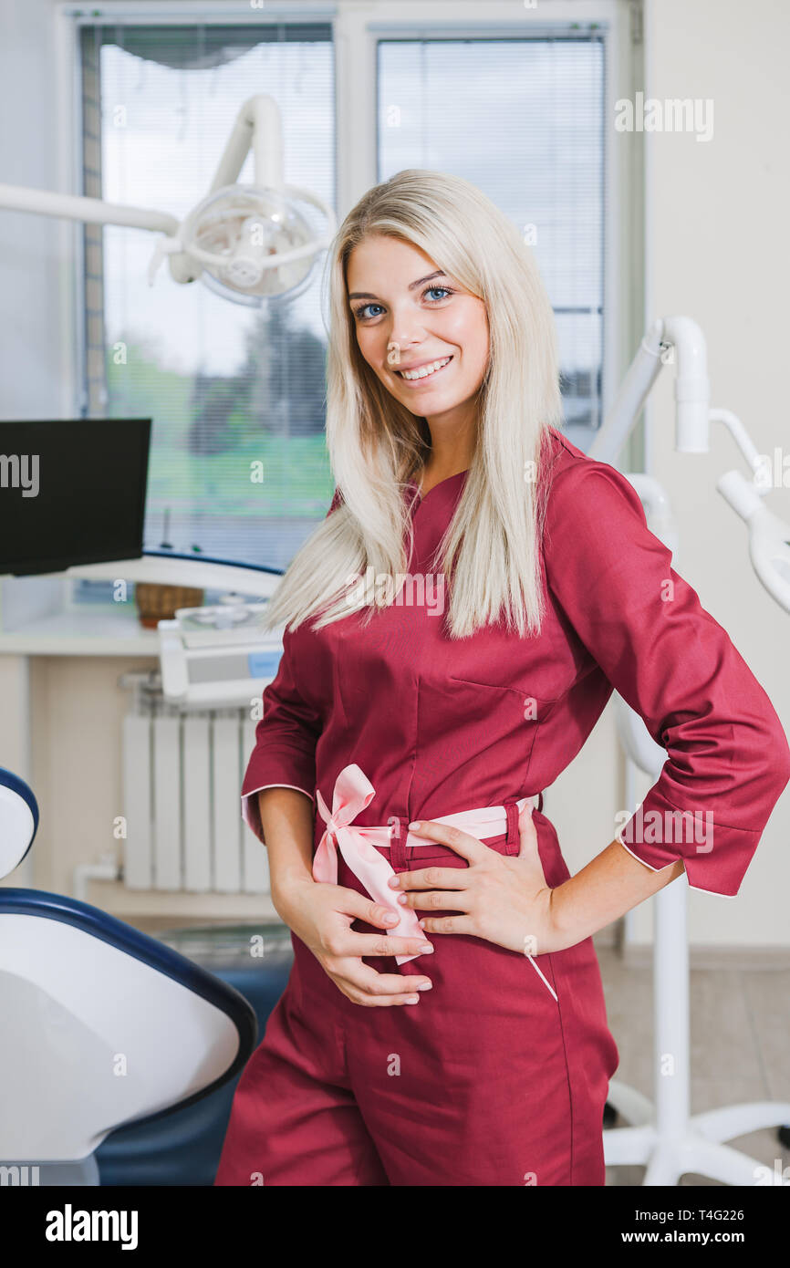 Dentista donna in uniforme in piedi in studio dentistico nelle vicinanze  dell'apparecchiatura. Concetto sano Foto stock - Alamy