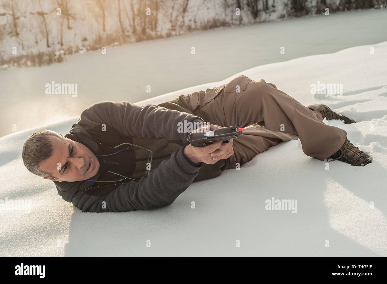 Istruttore di dimostrare la posizione del corpo di combattimento di spari in inverno la neve profonda. Advanced combattimenti tattici corsi di tiro all'aperto sul poligono di tiro Foto Stock