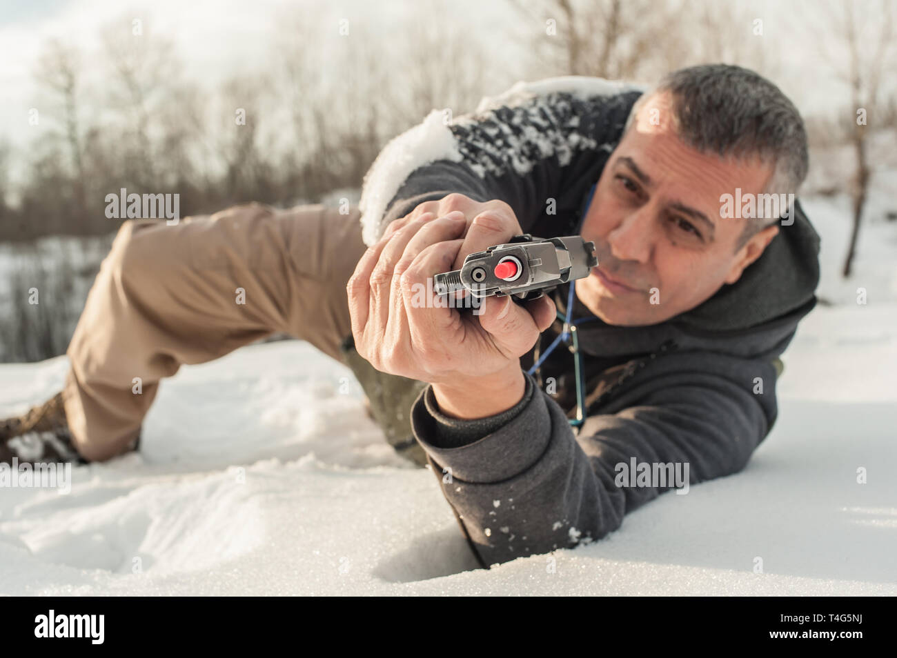 Istruttore di dimostrare la posizione del corpo di combattimento di spari in inverno la neve profonda. Advanced combattimenti tattici corsi di tiro all'aperto sul poligono di tiro Foto Stock