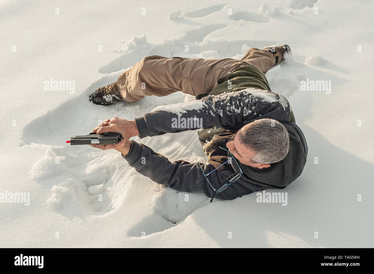 Istruttore di dimostrare la posizione del corpo di combattimento di spari in inverno la neve profonda. Advanced combattimenti tattici corsi di tiro all'aperto sul poligono di tiro Foto Stock