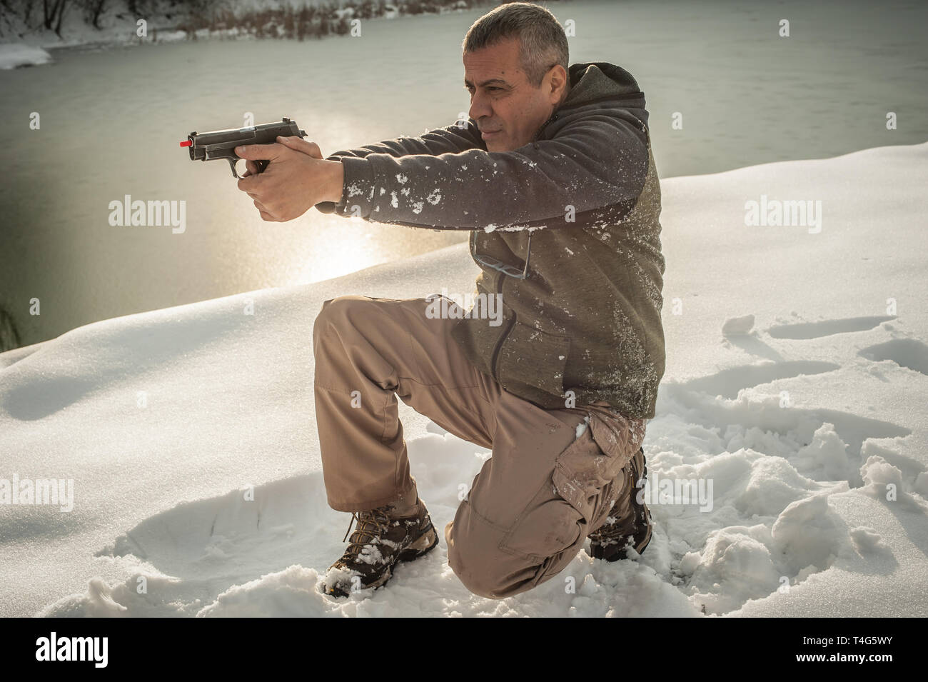 Istruttore di dimostrare la posizione del corpo di combattimento di spari in inverno la neve profonda. Advanced combattimenti tattici corsi di tiro all'aperto sul poligono di tiro Foto Stock