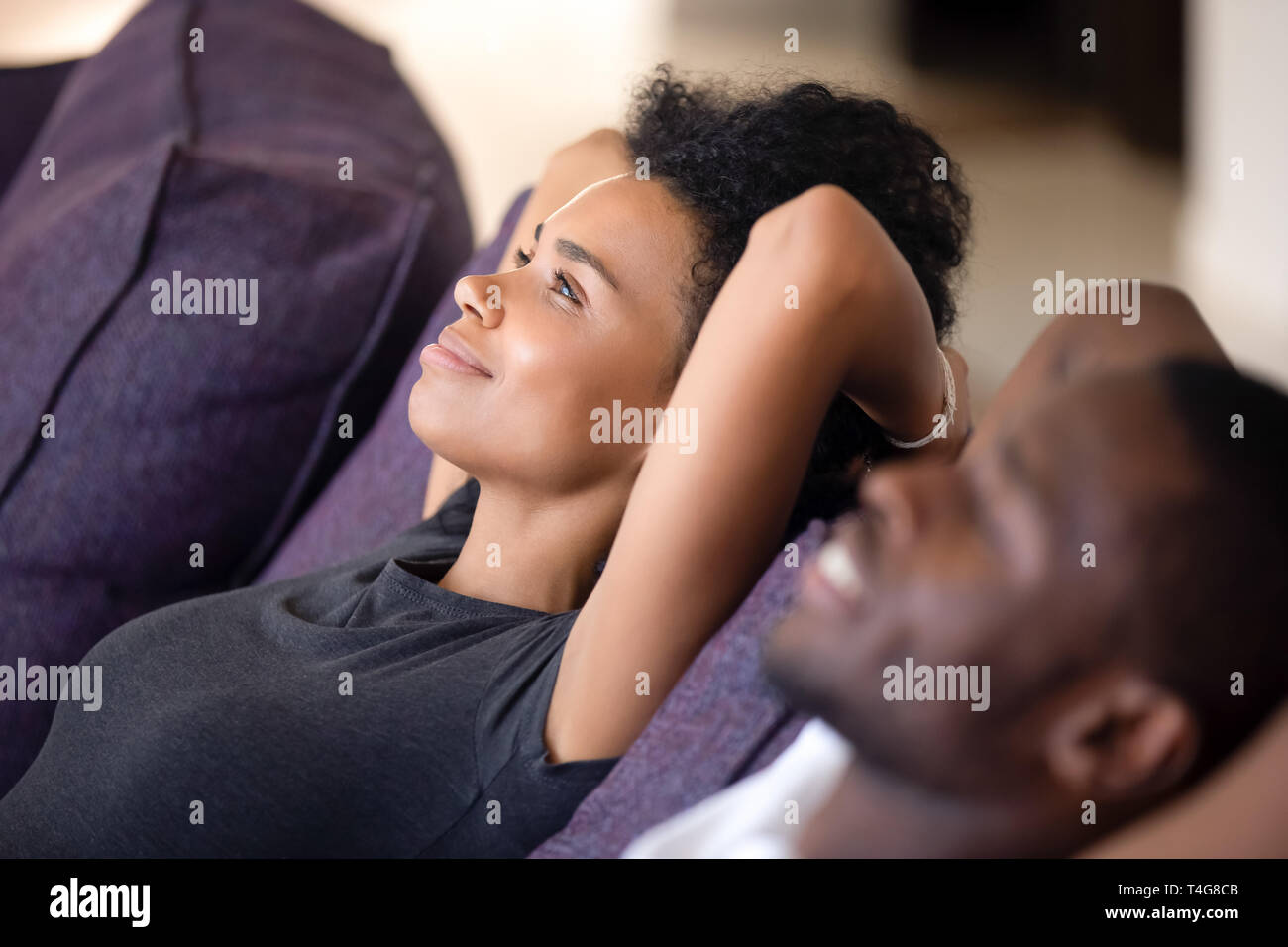 Close up tranquillo americano africano giovane rilassarsi su comodi divani Foto Stock
