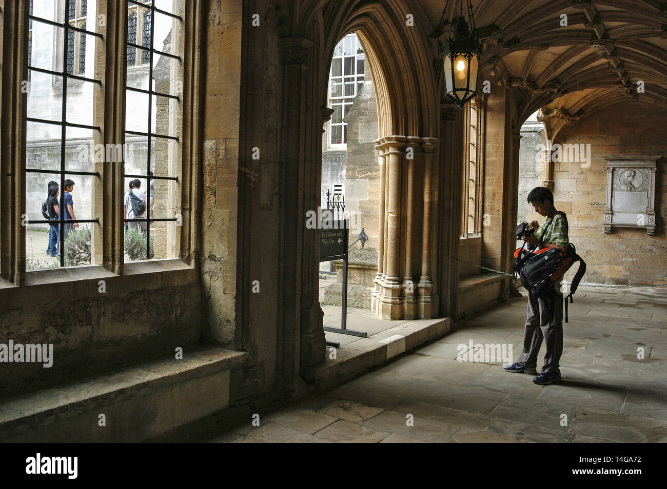 Un visitatore asiatico con la sua telecamera entro i chiostri del Christ Church College di Oxford, Gran Bretagna Foto Stock