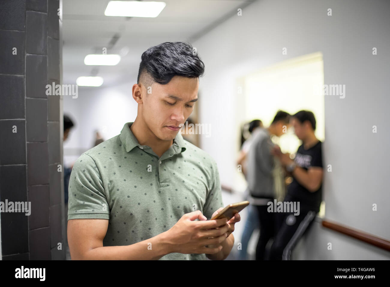 Asian uomini belli concentrandosi su smartphone | digitando messaggio sul cellulare Foto Stock