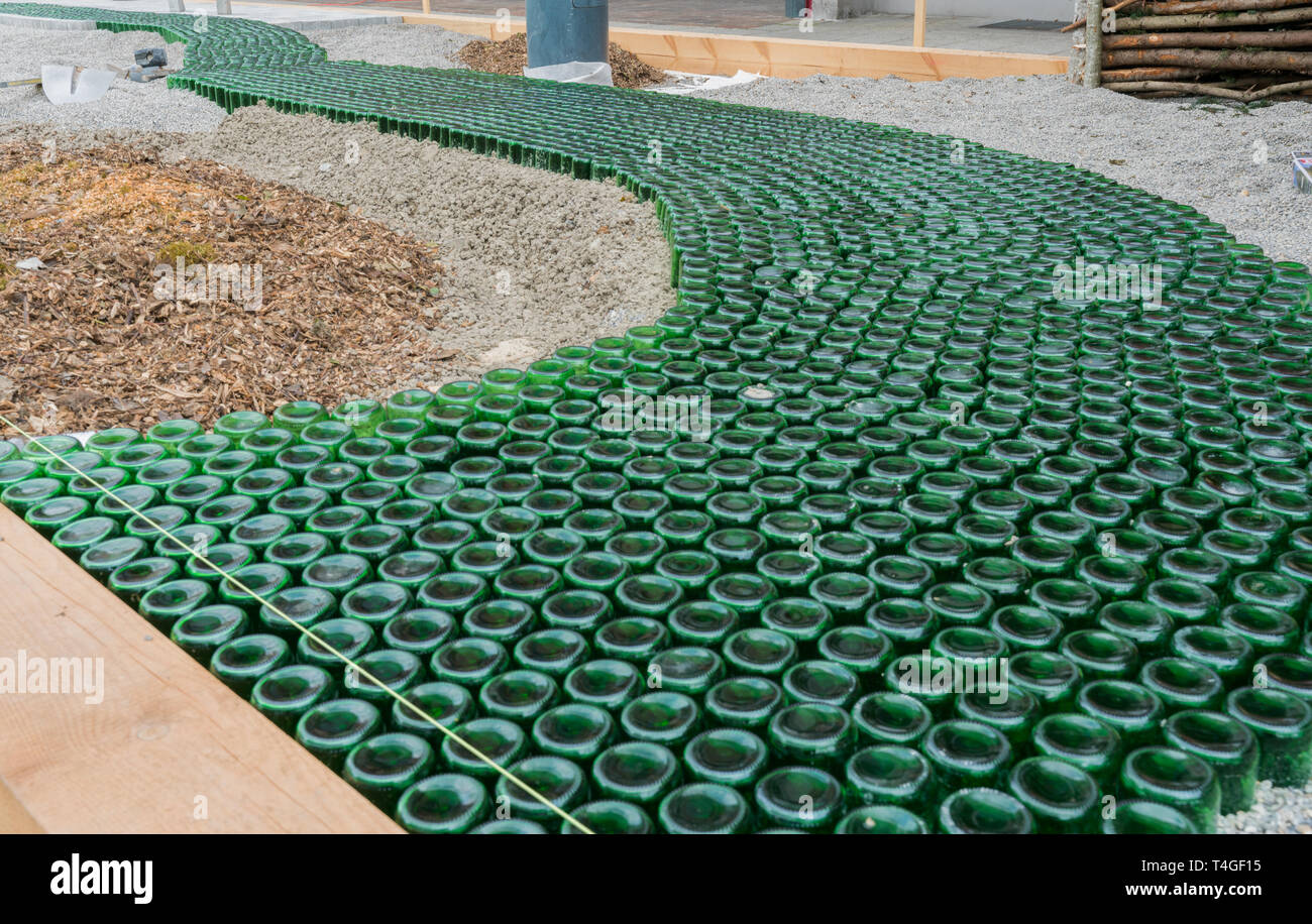 Giardinaggio sito in costruzione di una pietra naturale cortile con un innovativo bottiglia di vetro la passerella Foto Stock