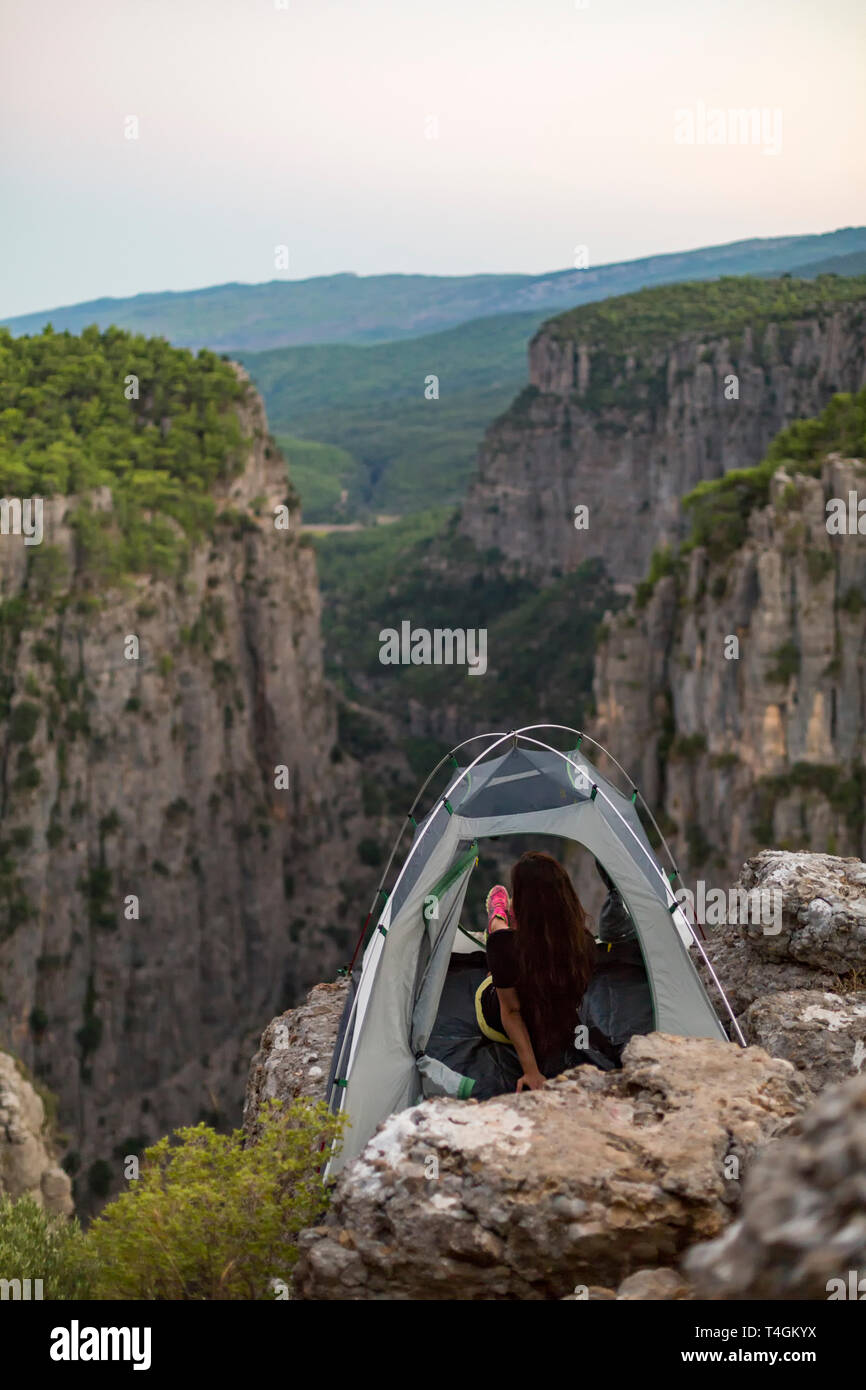 Le ragazze della giovane ragazza che ha preso una foto del paesaggio dall'interno della tenda di accampamento Foto Stock