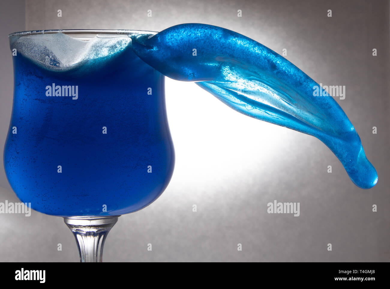 Blu di spruzzi di acqua in un bicchiere Foto Stock