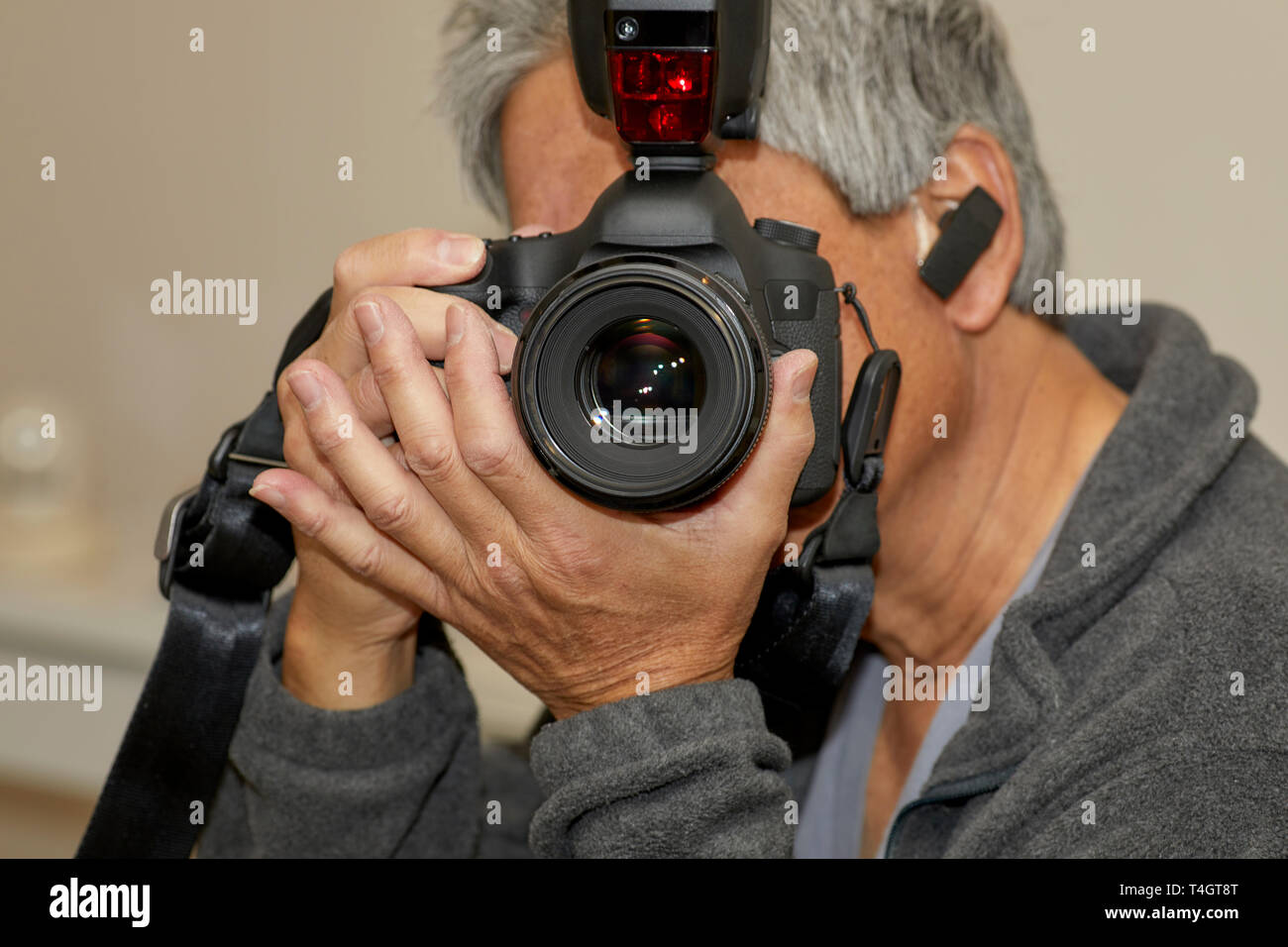 L'uomo tenendo un 35mm Fotocamera reflex digitale in preparazione per scattare una fotografia con la profondità di campo Foto Stock