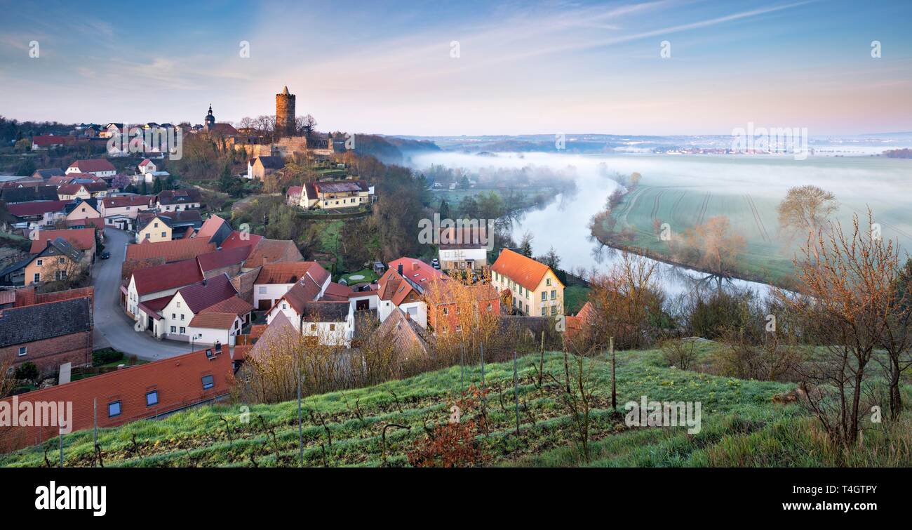 Vista del villaggio di Schonburg e il castello di Saale valley, nebbia di mattina sulla Saale, vicino a Naumburg, Sassonia-Anhalt, Germania Foto Stock