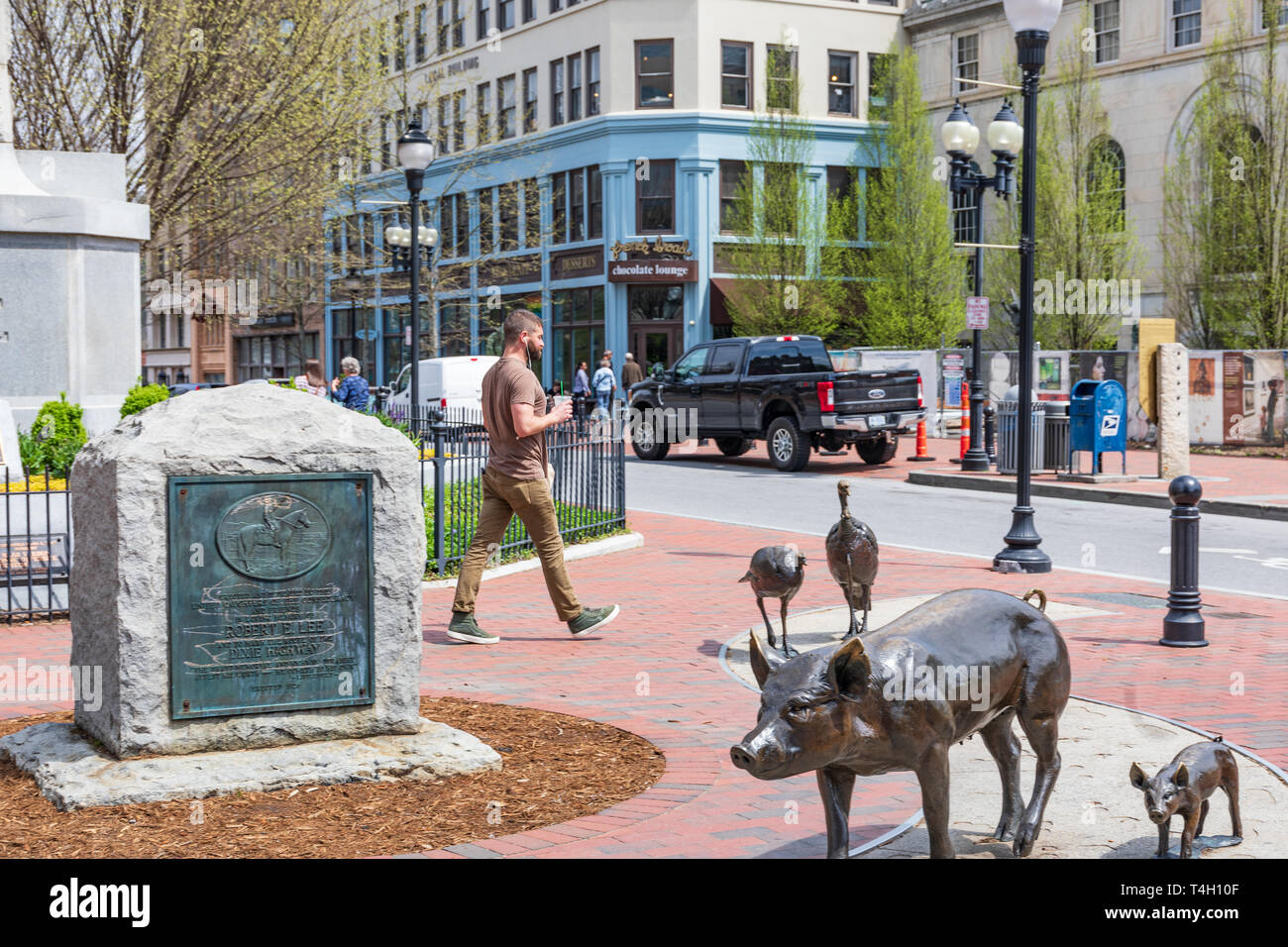 ASHEVILLE, NC, Stati Uniti d'America-4/11/19: Un uomo cammina attraverso il Broadway ingresso alla Piazza Pack include un monumento a Robert E. Lee e sculture di animali. Foto Stock