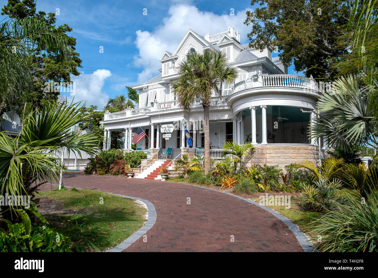 Vista frontale del bianco vintage Curry Mansion Inn in mattoni con vialetto e palme Foto Stock