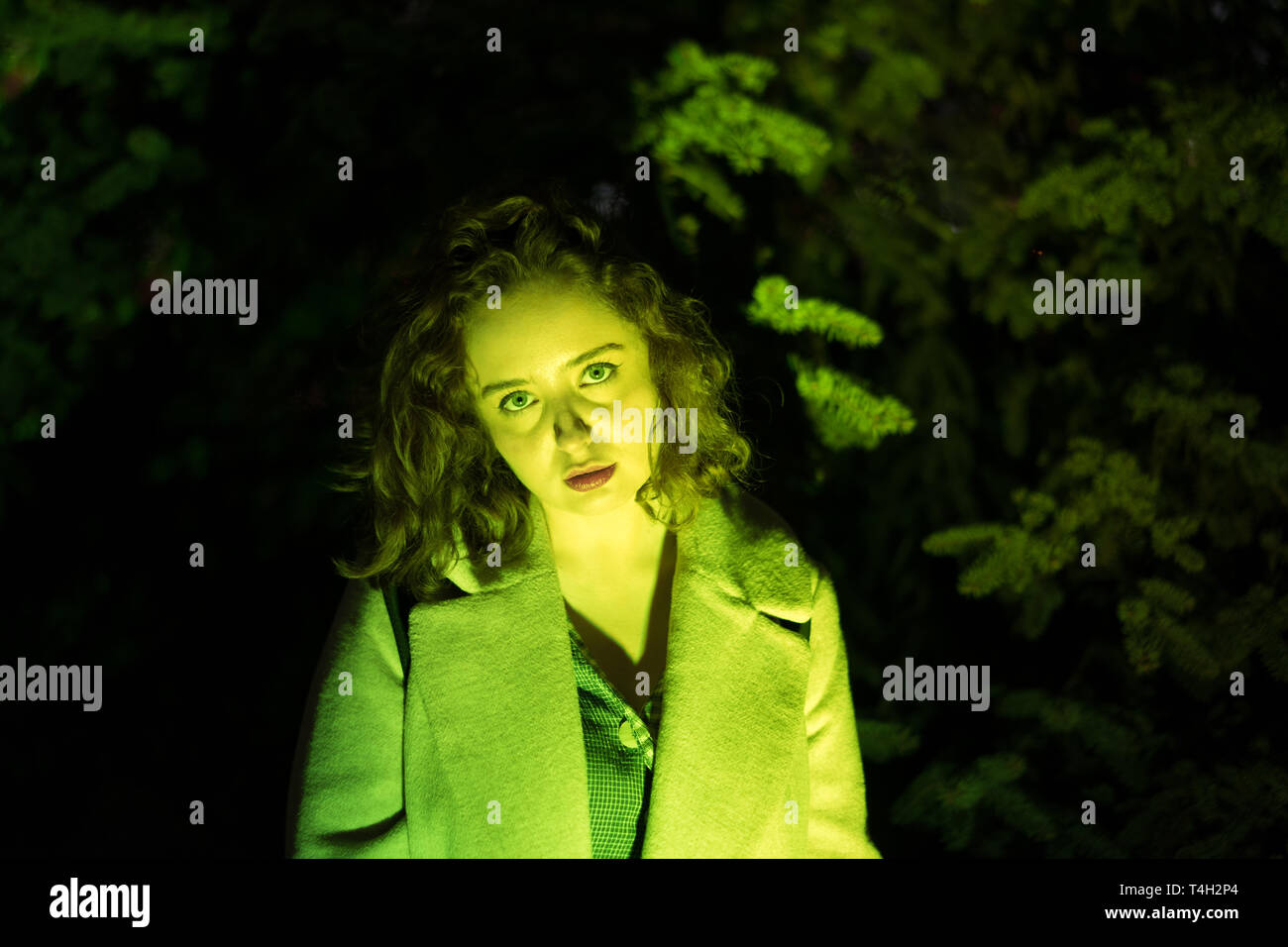 Ritratto di una misteriosa donna bella in illuminazione verde. Foto Stock