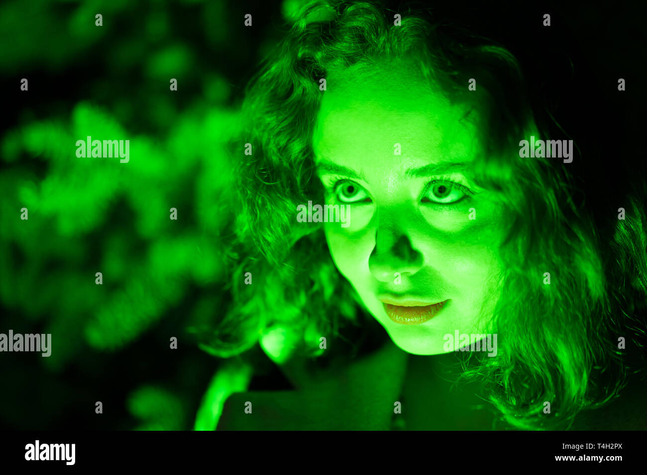 Ritratto di una misteriosa donna bella in illuminazione verde. Foto Stock