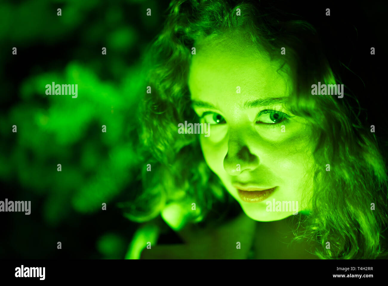 Ritratto di una misteriosa donna bella in illuminazione verde. Foto Stock