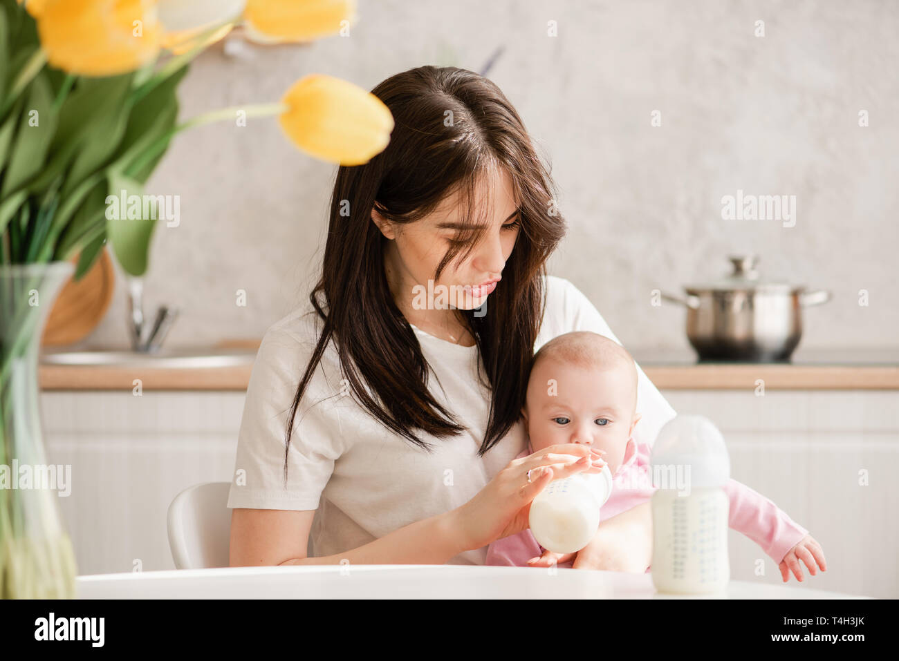 Giovane donna di posa e di alimentazione di baby girl Foto Stock