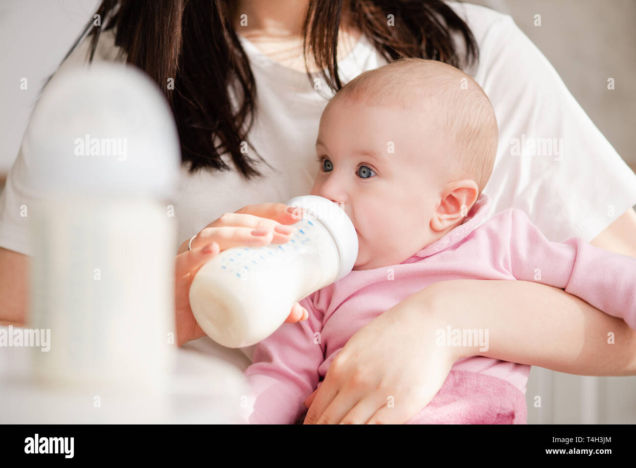Close-up del neonato alimentazione con formula in una bottiglia. Foto Stock