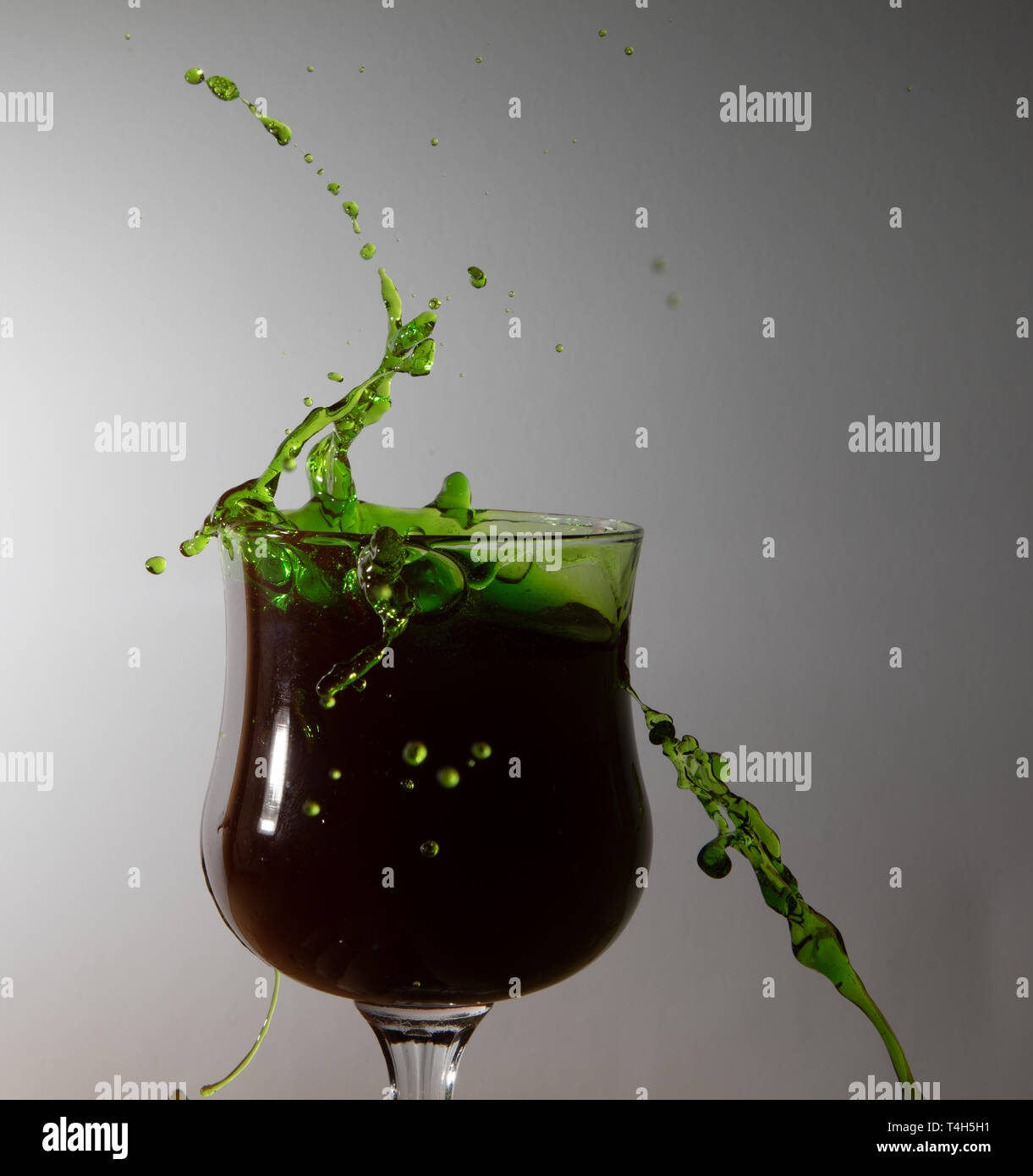 Verde di spruzzi di acqua in un bicchiere Foto Stock