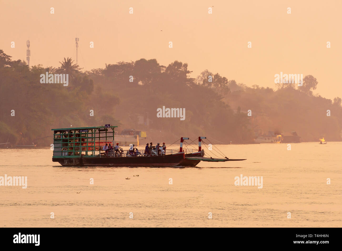 Chua Ba Nam, Vietnam - Marzo 6, 2019 - Traghetto traffico solcare il fiume Mekong attraverso il Vietnam rurale al tramonto. Foto Stock