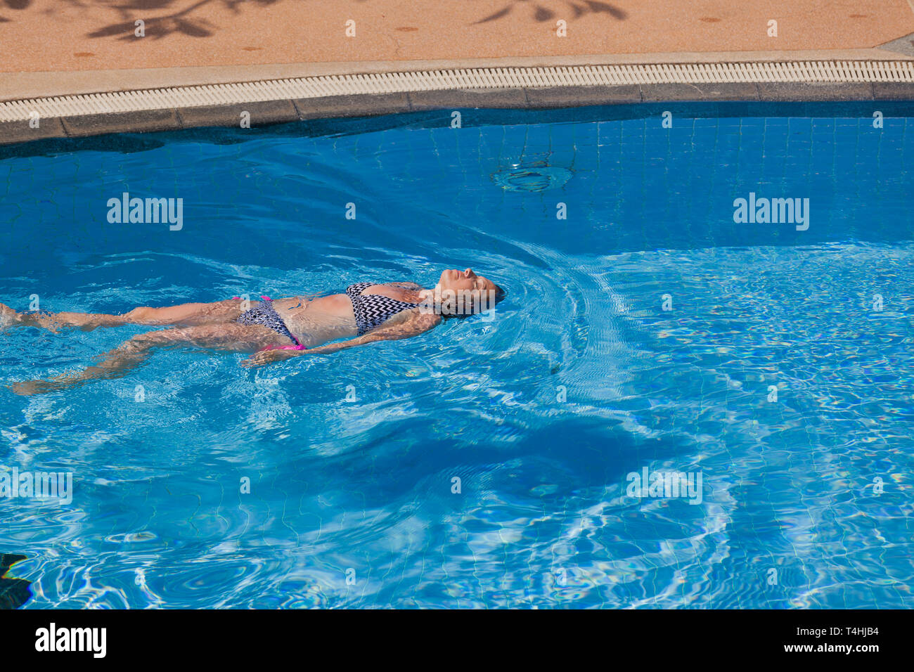 Una donna mentre il dorso in una piscina Foto Stock