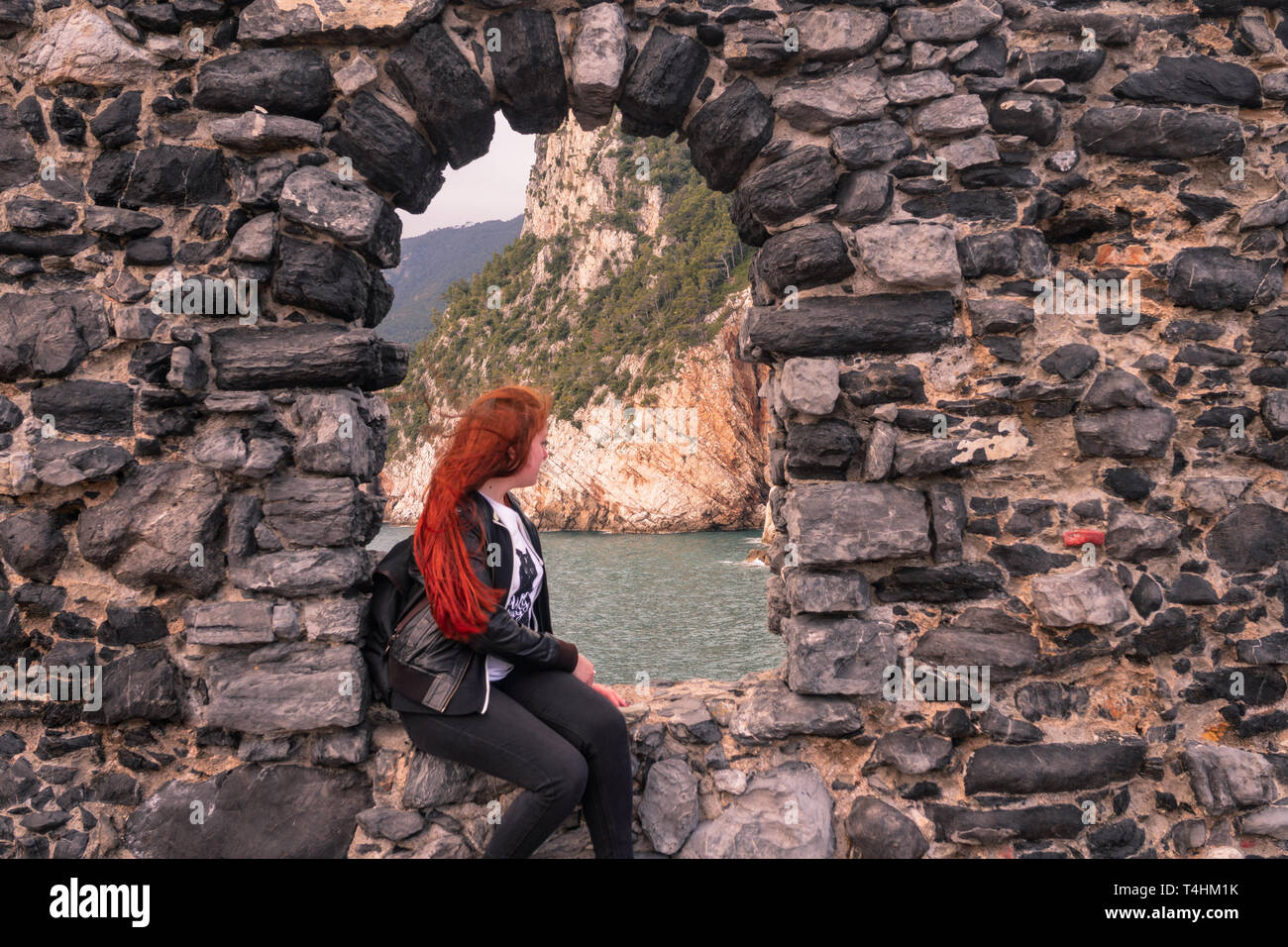 Ragazza sta guardando oltre la scogliera a Portovenere. La vecchia finestra è situato vicino al famoso Cinque Terre Foto Stock