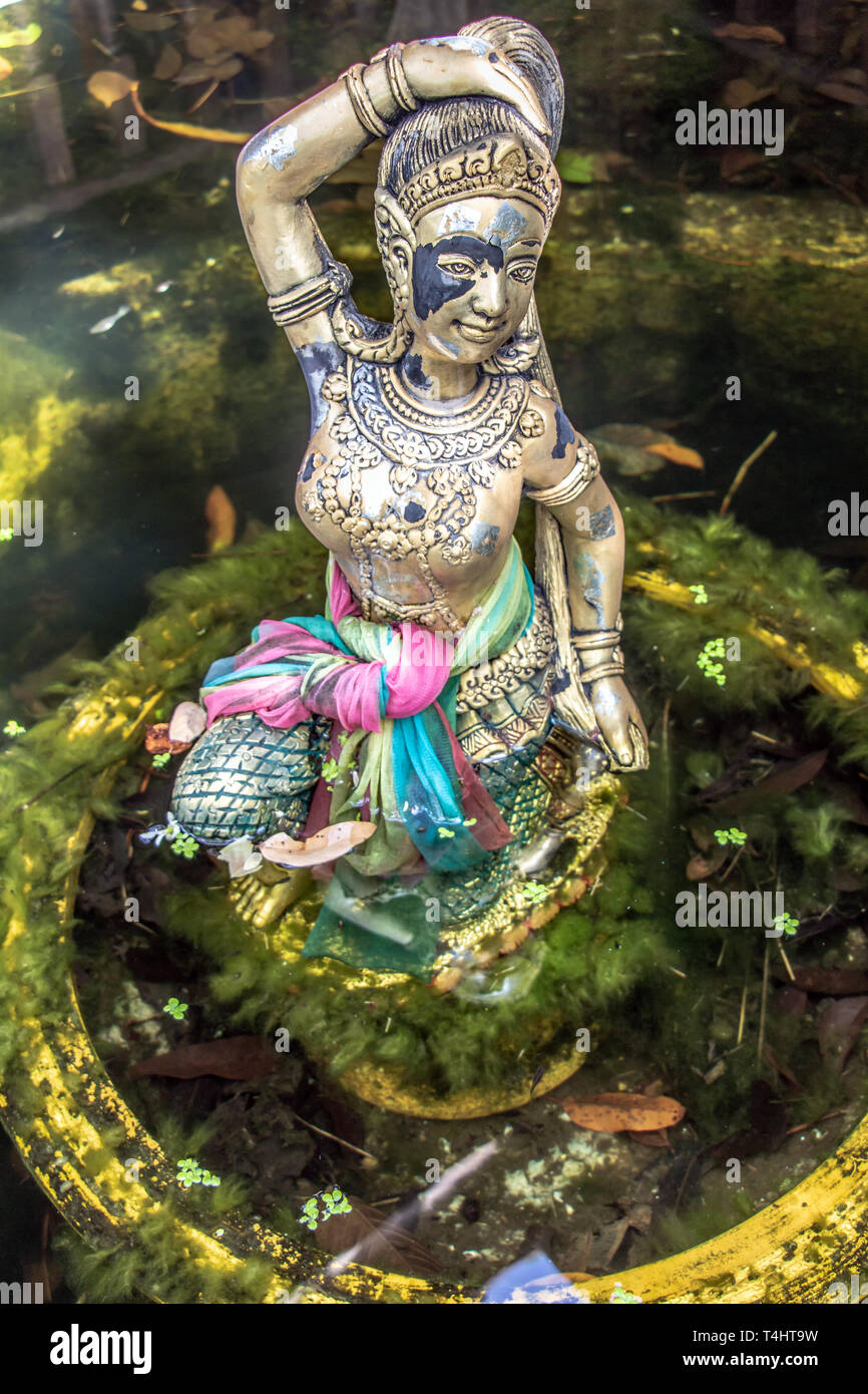 Statua religiosa alla fontana, Thailandia. La madre Terra schiacciando i suoi capelli. Foto Stock