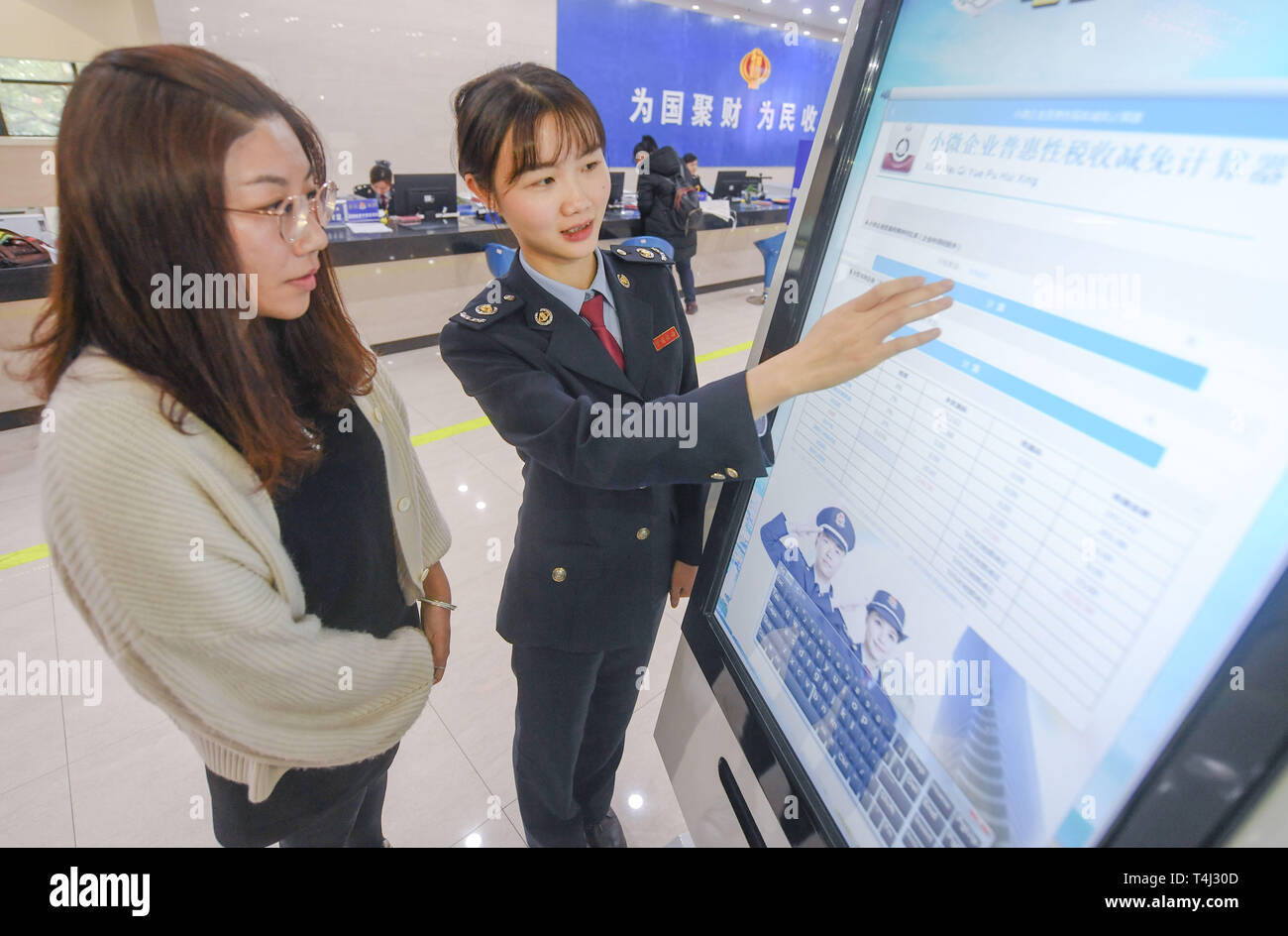 Pechino, la Cina della provincia del Fujian. 1 apr, 2019. Un membro del personale (R) spiega in un contribuente circa una nuova politica in materia di IVA la riduzione a una tassa locale ufficio di presidenza Fengze nel distretto di Quanzhou, a sud-est della Cina di provincia del Fujian, 1 aprile 2019. Credito: canzone Weiwei/Xinhua/Alamy Live News Foto Stock