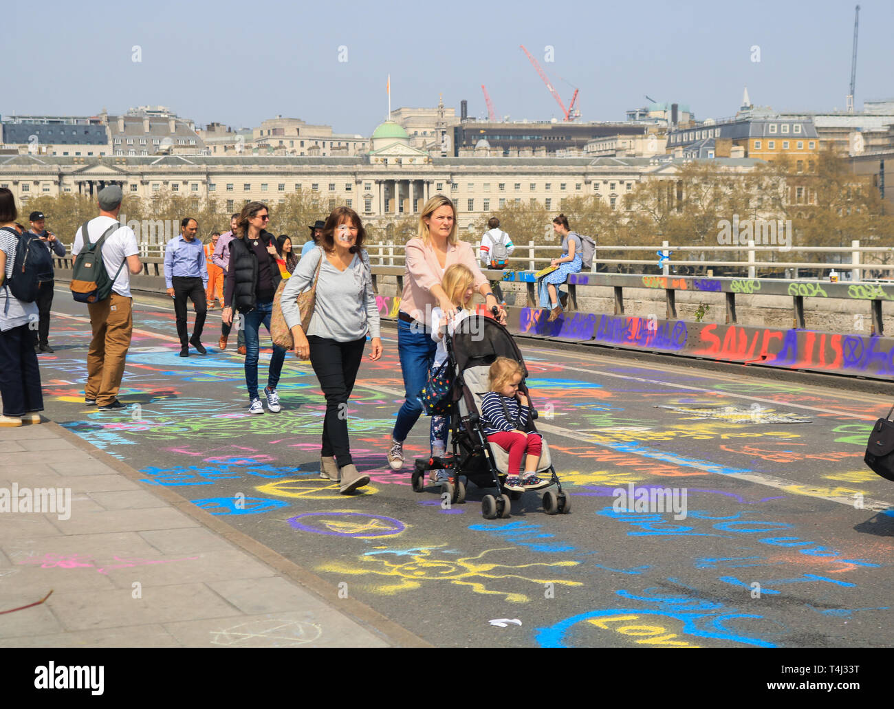 Londra, Regno Unito. Xvii Apr, 2019. I pedoni a piedi sul ponte di Waterloo coperto di graffiti di messaggi al giorno 3 della ribellione di estinzione protesta come parte di una protesta in corso per costringere il governo britannico a dichiarare una crisi climatica emergenza in 2 settimana di campagna Credito: amer ghazzal/Alamy Live News Foto Stock