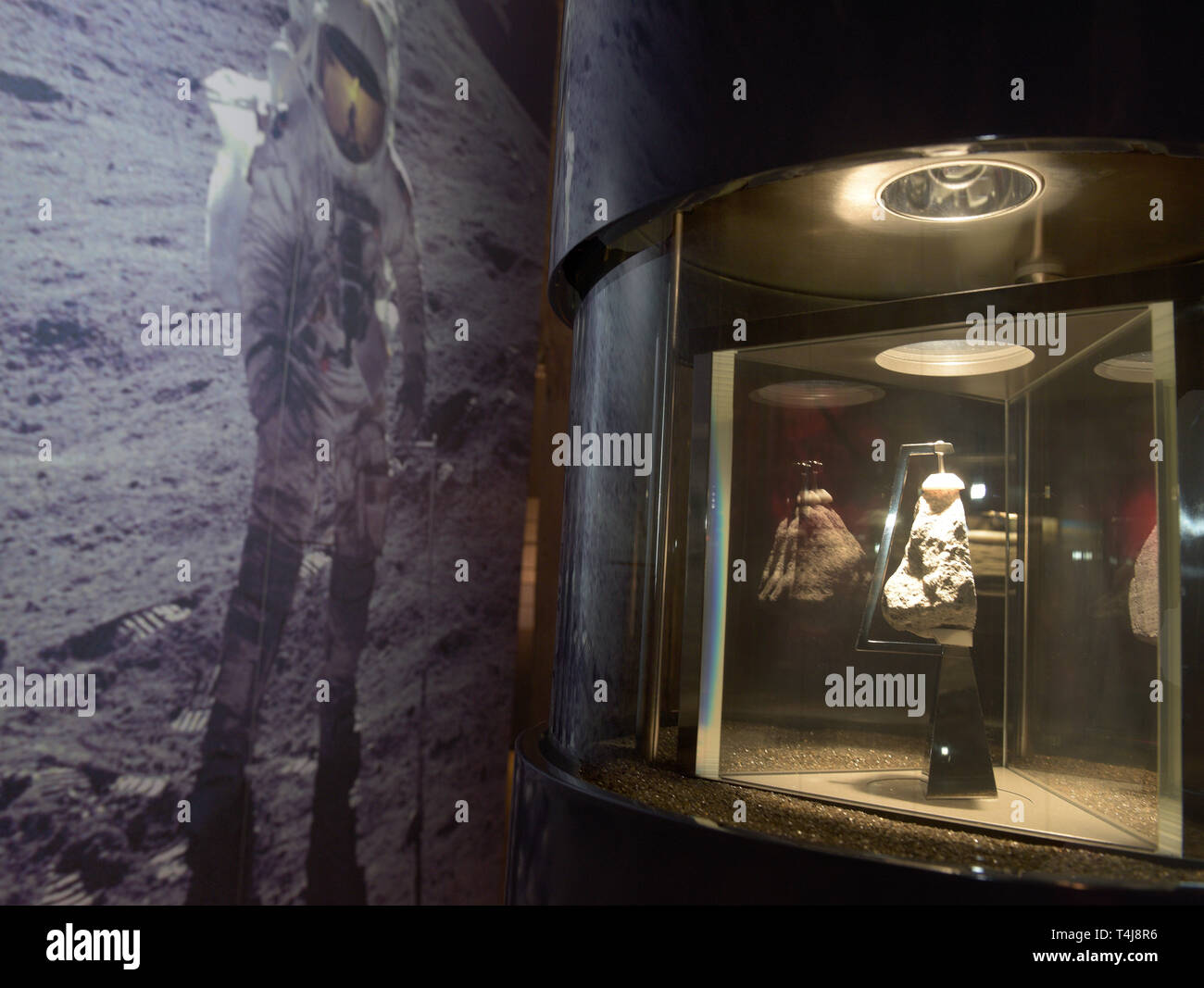 16 aprile 2019, il Land della Baviera, Nördlingen: Nel cratere Ries museo un pezzo di roccia lunare è esposto in una vetrina accanto alla registrazione di un atterraggio sulla luna. Il Nördlinger Ries, che è stato creato da un meteorite impatto, presenta analoghe strutture di roccia a quelli che si trovano sulla luna. Pertanto la NASA ha inviato la sua astroauts a nord di Svevia per preparare la luna missioni di carico. Foto: Stefan Puchner/dpa Foto Stock