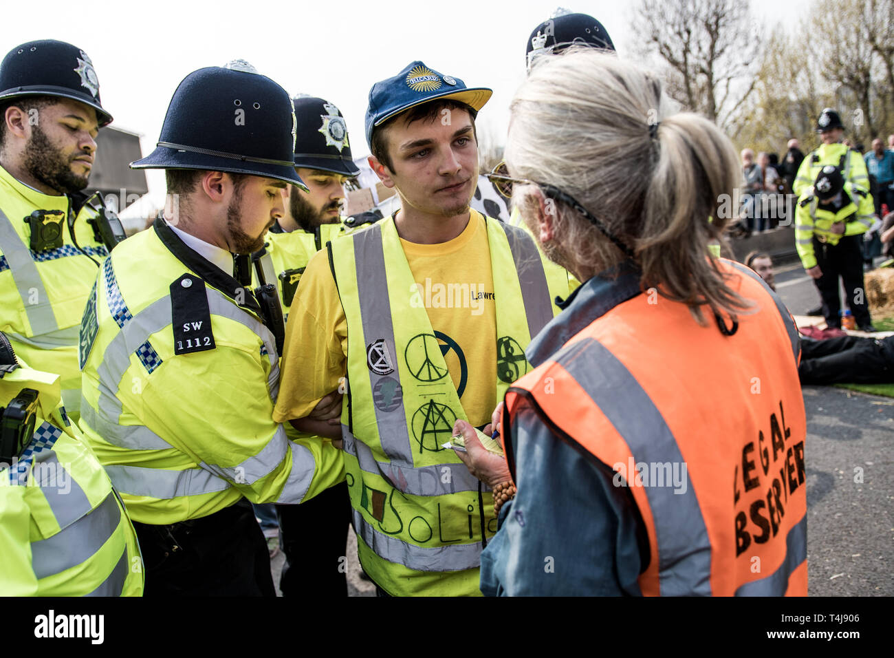 Un manifestanti è essere arrestato da funzionari di polizia visto che parla con un osservatore giuridico allo stesso tempo durante la ribellione di estinzione sciopero a Londra. Estinzione della ribellione manifestanti hanno bloccato cinque centrali di Londra per protestare contro il governo inazione sul cambiamento climatico. Foto Stock