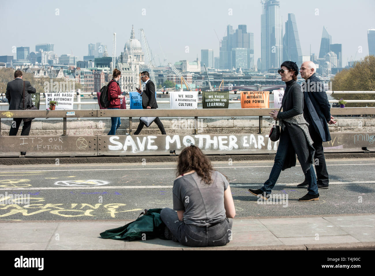 Londra, Regno Unito. Xvii Apr, 2019. Pic mostra una donna seduta e pedoni passando sul ponte durante la ribellione di estinzione sciopero a Londra.estinzione della ribellione manifestanti hanno bloccato cinque centrali di Londra per protestare contro il governo inazione sul cambiamento climatico. Credito: Brais G. Rouco/SOPA Immagini/ZUMA filo/Alamy Live News Foto Stock