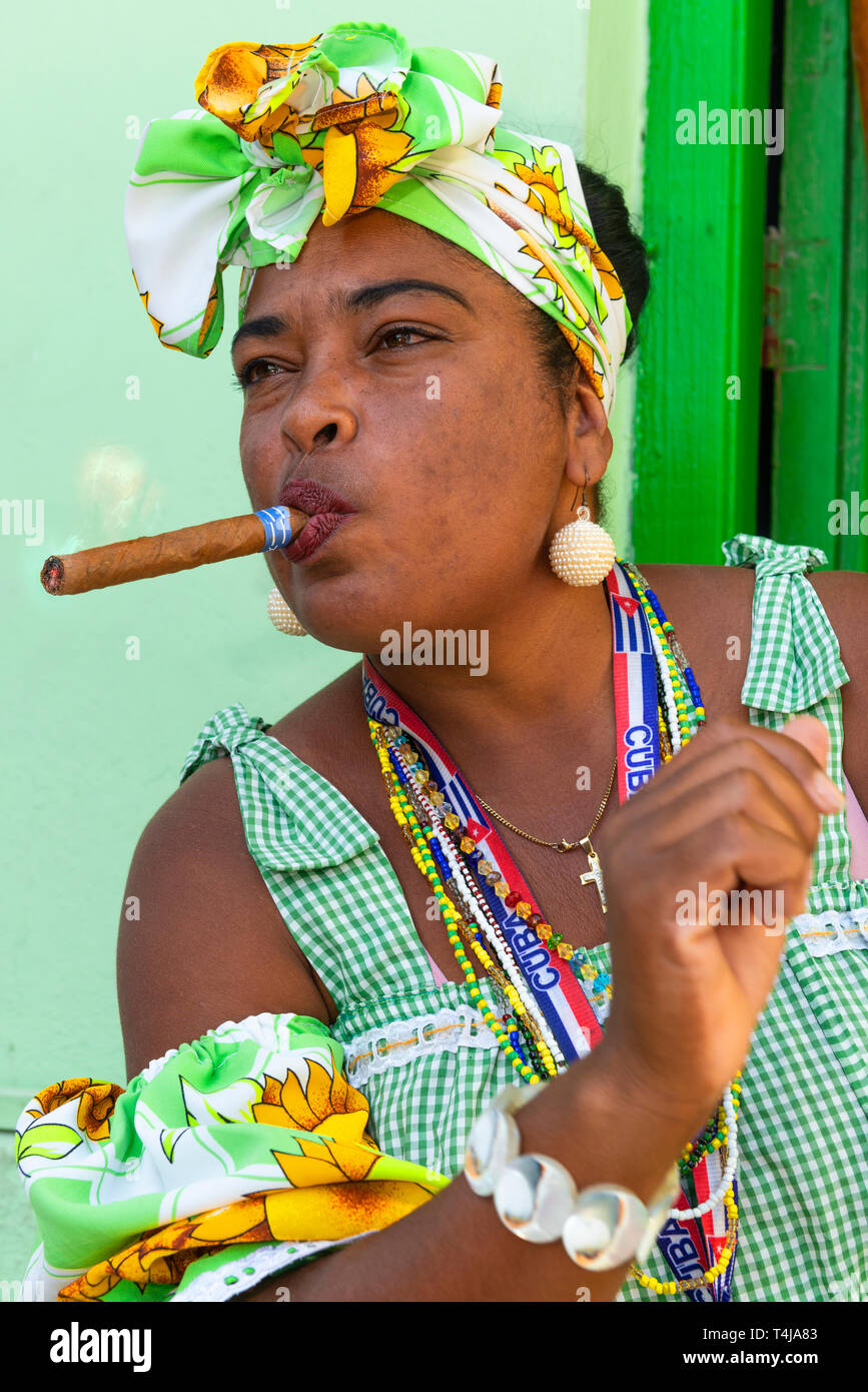 Fumatori di sigari lady in posa per i turisti in un modo porta vicino Convento de San Francisco de Asís nella Vecchia Havana, Cuba,dei Caraibi Foto Stock