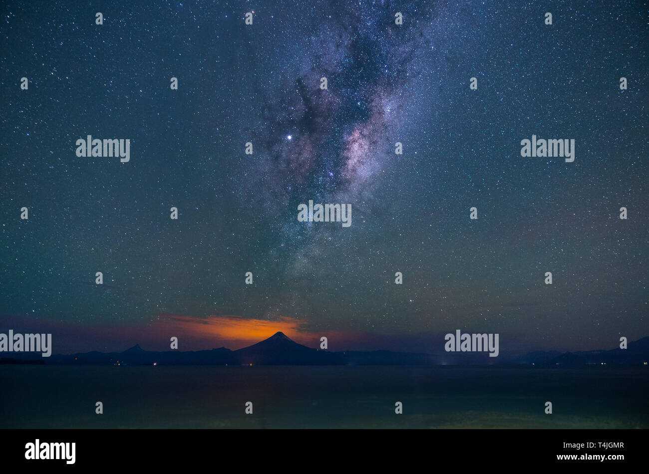 Ampio paesaggio di notte sulle rive del Lago Llanquihue. La Via Lattea passando attraverso il Osorno e Calbuco vulcani Foto Stock