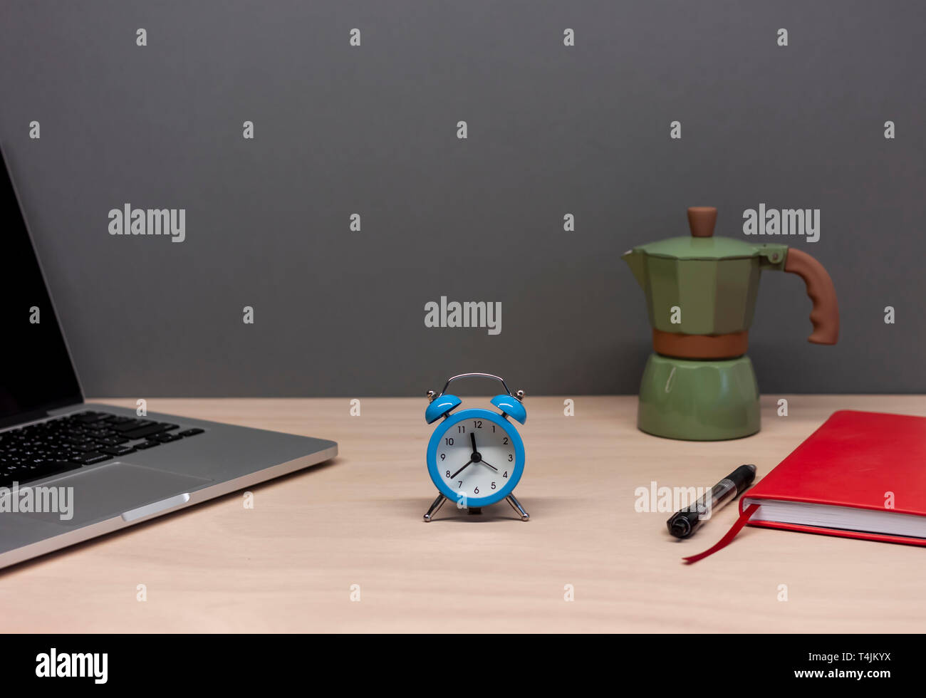 Tavolo di lavoro con laptop notebook sveglia e caffè italiano maker Foto Stock