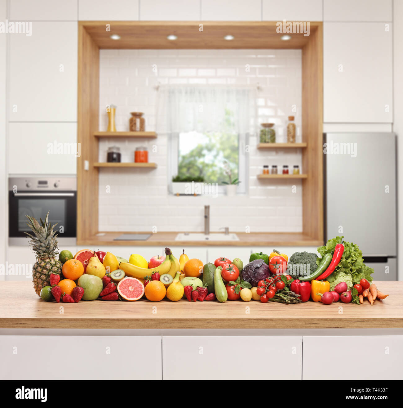 Frutta e verdura collocato su un banco di legno in una moderna cucina Foto Stock