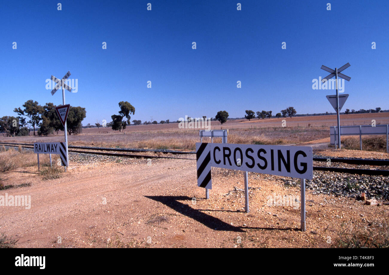 ATTRAVERSAMENTO FERROVIARIO E SEGNALI DI AVVERTIMENTO, OUTBACK NEW SOUTH WALES, AUSTRALIA. Foto Stock