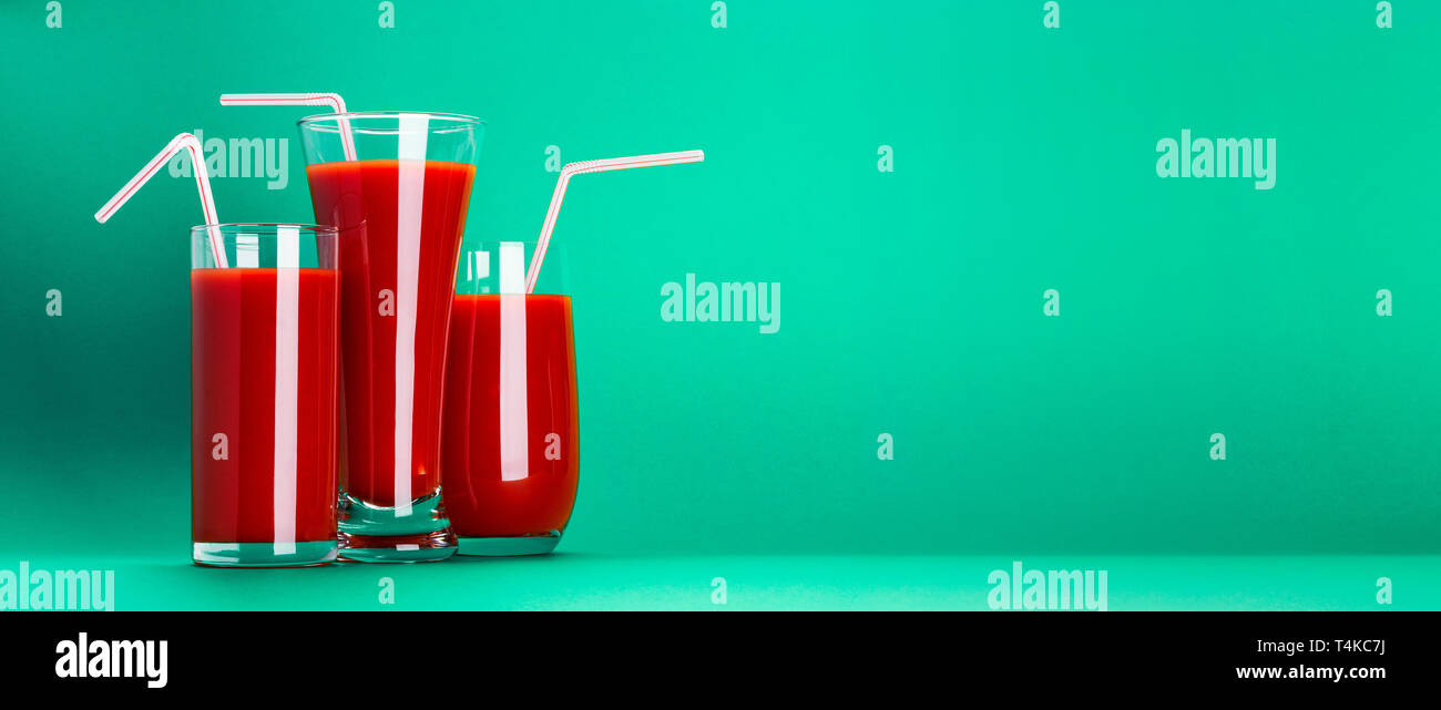 Bicchiere di succo di pomodoro isolato su sfondo verde con spazio di copia Foto Stock