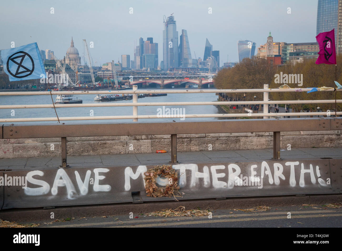 Un 'Save Madre Terra' banner dipinta sul ponte di Waterloo per l'estinzione della ribellione di dimostrazione con la City di Londra dietro Foto Stock