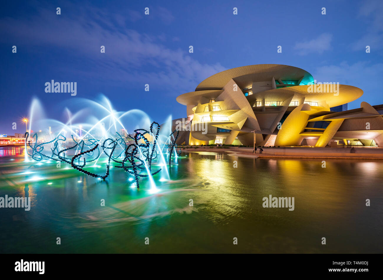 Vista notturna del nuovo Museo Nazionale del Qatar con fontane illuminate a Doha , Qatar. Architetto Jean Nouvel. Foto Stock